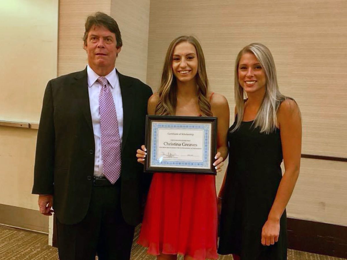 A scholarship recipient holding her certificate